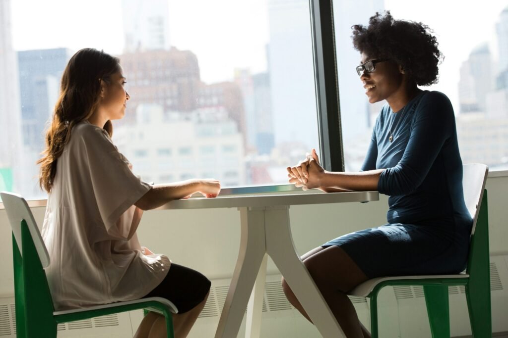 two women sitting beside duas mulheres sentadas ao lado da mesa e conversando